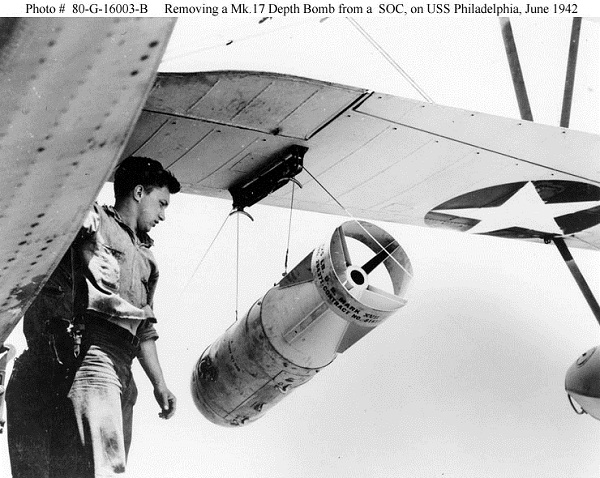  Mk. 17 depth bomb is being unloaded from a SOC Seagull scout plane on board the USS Philadelphia (CL-41) during an Atlantic U-boat sweep near Panama in June 1942.  